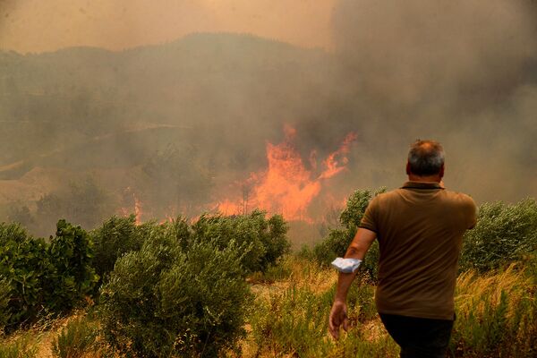 Мкжчина на фоне лесного пожара (29 июля 2021). Турция - Sputnik Армения