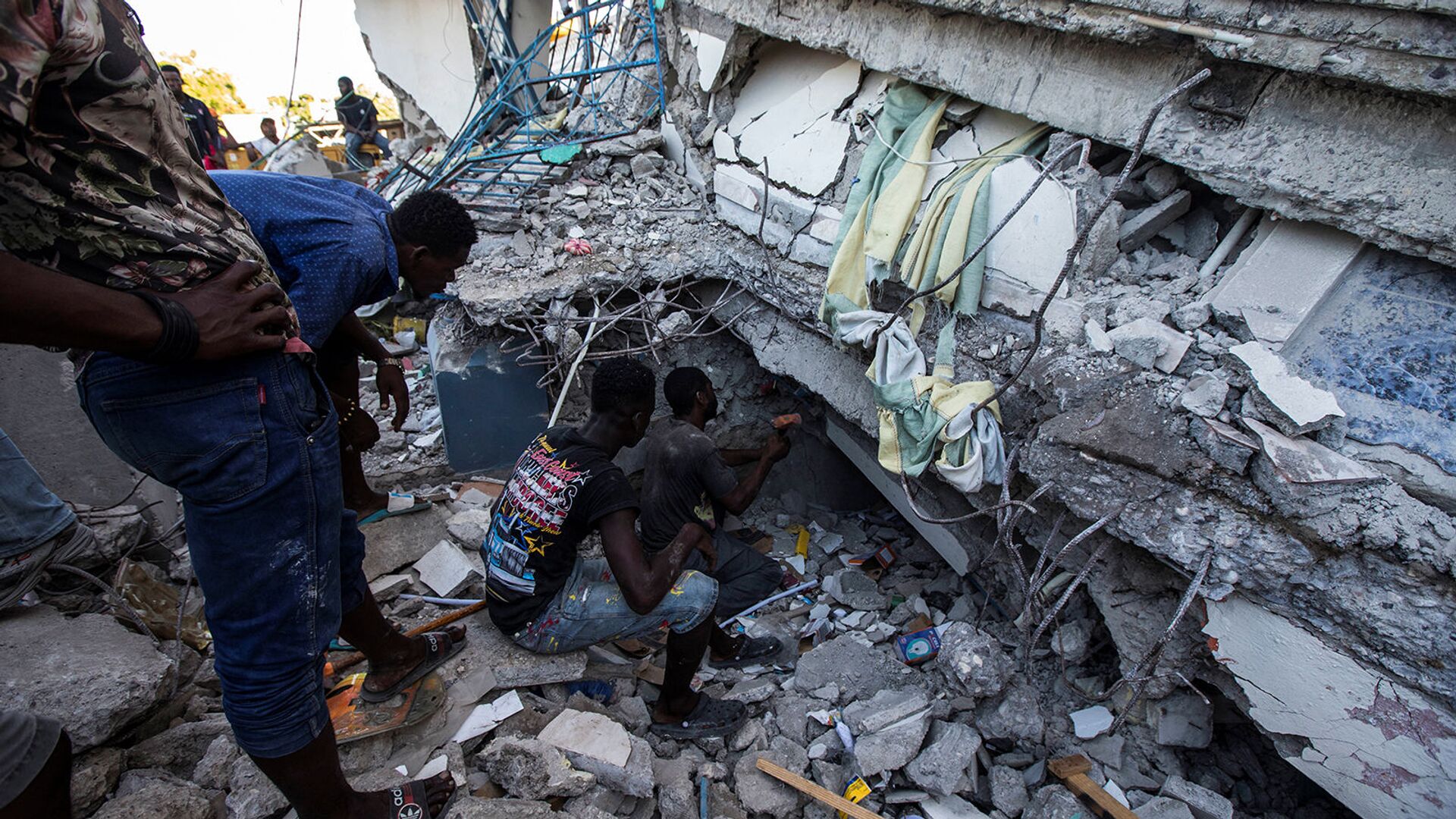 Люди ищут выживших в доме, разрушенном в результате землетрясения силой 7,2 балла в Ле-Ке (15 августа 2021). Гаити - Sputnik Армения, 1920, 18.08.2021