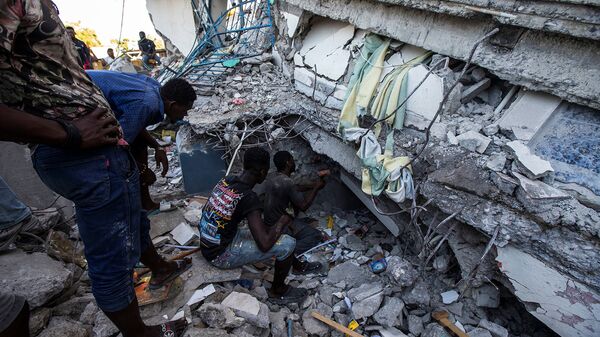 Люди ищут выживших в доме, разрушенном в результате землетрясения силой 7,2 балла в Ле-Ке (15 августа 2021). Гаити - Sputnik Армения