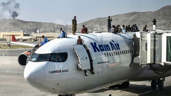 Афганцы забираются на самолет в аэропорту Кабула, пытаясь спастись из страны - Sputnik Армения