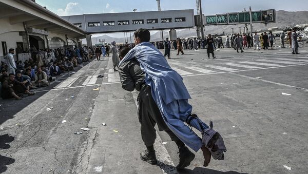 Волонтер с раненым афганцем в аэропорту Кабула  - Sputnik Армения