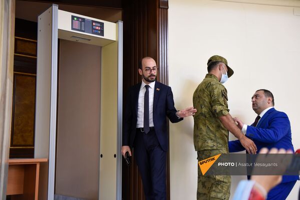 Сотрудник службы безопасности парламента беседует с депутатами у входа в зал заседаний (25 августа 2021). Еревaн - Sputnik Армения
