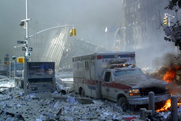 Поврежденный автомобиль скорой помощи и покрытая обломками улица после обрушения первого здания Всемирного торгового центра в Нью-Йорке - Sputnik Армения