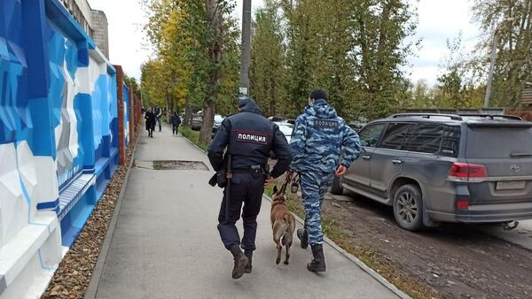 Сотрудники полиции со служебной собакой на улице после инцидента со стрельбой в Пермском государственном университете (20 сентября 2021). Пермь - Sputnik Армения