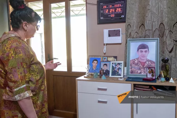 Лусине смотрит на фотографии погибшего сына - Sputnik Армения