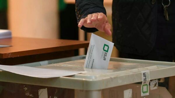 Избиратель закидывает бюллетень в избирательную урну во время выборов в органы местного самоуправления Грузии (2 октября 2021). Тбилиси - Sputnik Армения