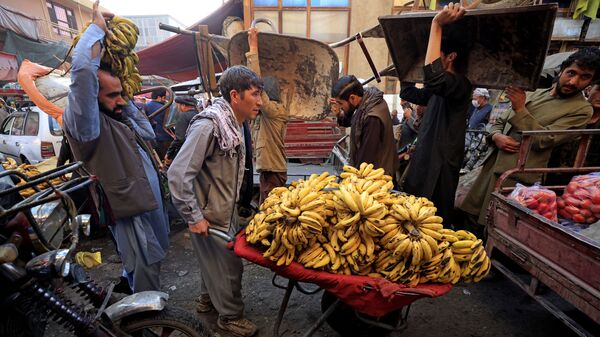 Мужчина толкает тачку с бананами на рынке в Кабуле - Sputnik Армения