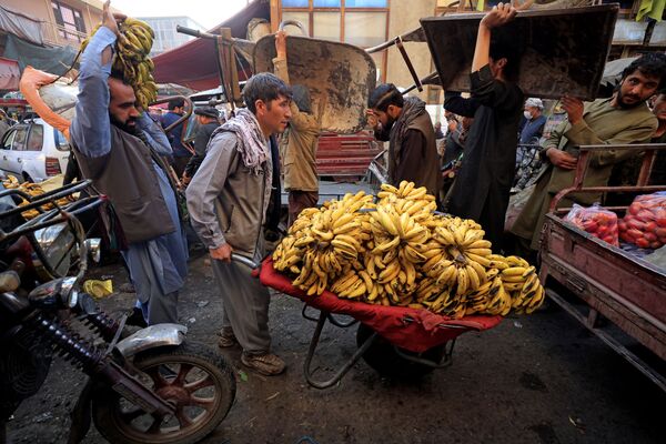 Мужчина толкает тачку с бананами на рынке в Кабуле. - Sputnik Армения