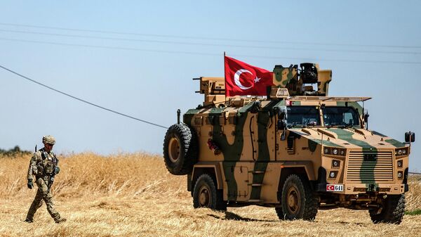 Американский солдат идет рядом с турецкой военной машиной во время совместного патрулирования с Турцией в сирийской деревне Аль-Хашиша на окраине города Таль-Абьяд вдоль границы с Турцией (8 сентября 2019). Сирия - Sputnik Армения