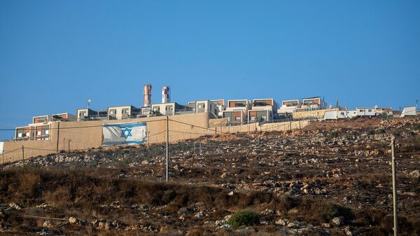 Израильский флаг на окружающей стене еврейского поселения Мигдалим на Западном берегу недалеко от палестинского города Наблус - Sputnik Армения