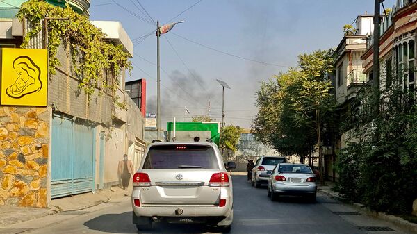 Автомобили движутся по дороге на фоне дыма, поднимающегося с места взрыва в Кабуле (2 ноября 2021). Афганистан - Sputnik Армения