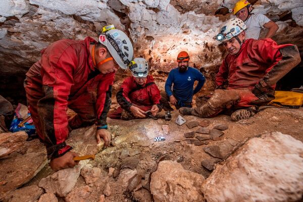 Археологи Национального института антропологии и истории наблюдают фрагменты глиняной посуды в пещере. - Sputnik Армения