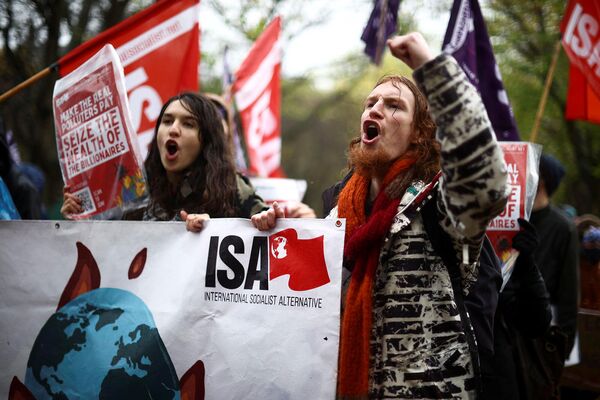 Демонстранты с флагами и транспарантами на акции протеста во время Конференции ООН по изменению климата (COP26) в Глазго. - Sputnik Армения