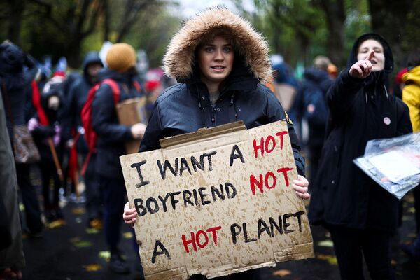 Девушка держит плакат с надписью &quot;Хочу горячего парня, а не горячую планету&quot; на акции протеста во время Конференции ООН по изменению климата (COP26) в Глазго. - Sputnik Армения