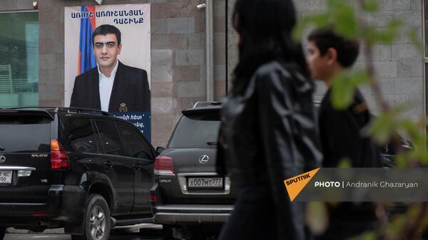 Люди проходят мимо агитационного предвыборного плаката блока Аруша Арушаняна в Горисе - Sputnik Армения