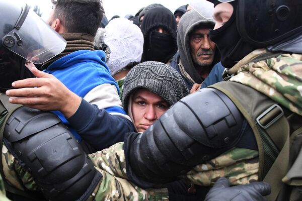 Беженцы под контролем белорусских военнослужащих во время получения гуманитарной помощи в лагере нелегальных мигрантов на белорусско-польской границе - Sputnik Армения
