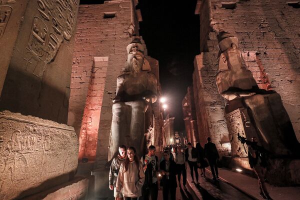 Посетители проходят мимо статуй древнеегипетского фараона Рамзеса II в храме Луксор. - Sputnik Армения