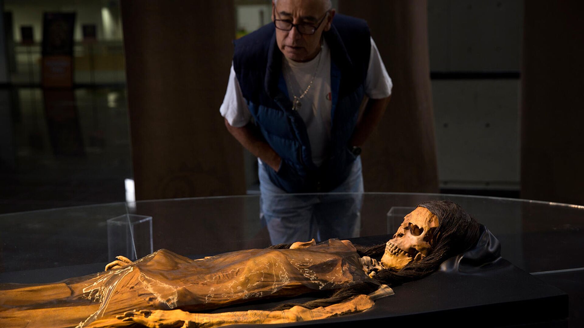 Посетитель Национального музея в Лиме смотрит на копию мумии Леди Цао, найденную в 2005 году на месте археологических раскопок Уака-эль-Брухо (5 июля 2017). Перу - Sputnik Армения, 1920, 28.11.2021