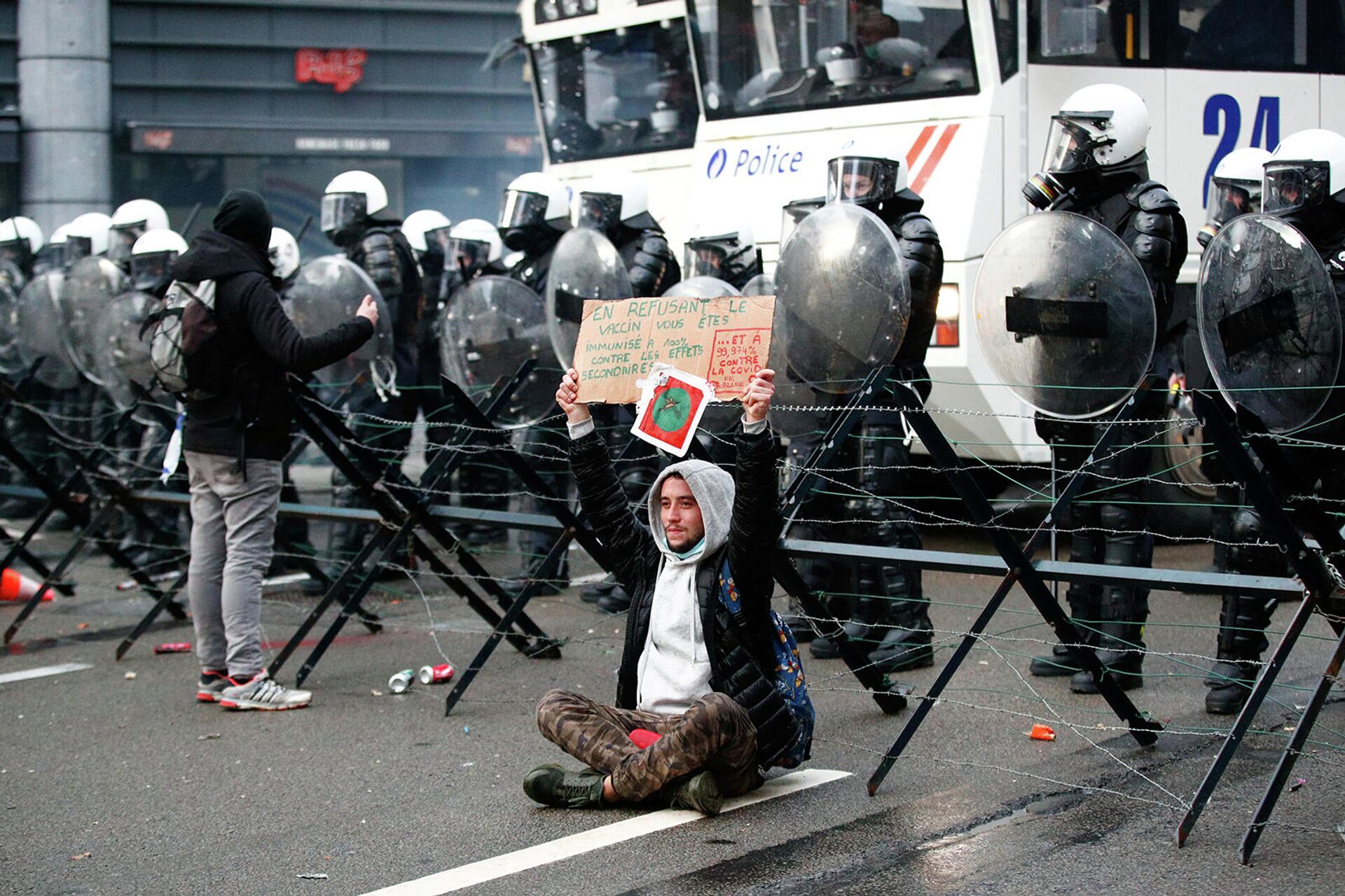 Демонстрант перед полицейскими во время акции протеста против ограничений бельгийского правительства, введенных для сдерживания распространения коронавирусной болезни (5 декабря 2021). Брюссель - Sputnik Армения, 1920, 05.12.2021