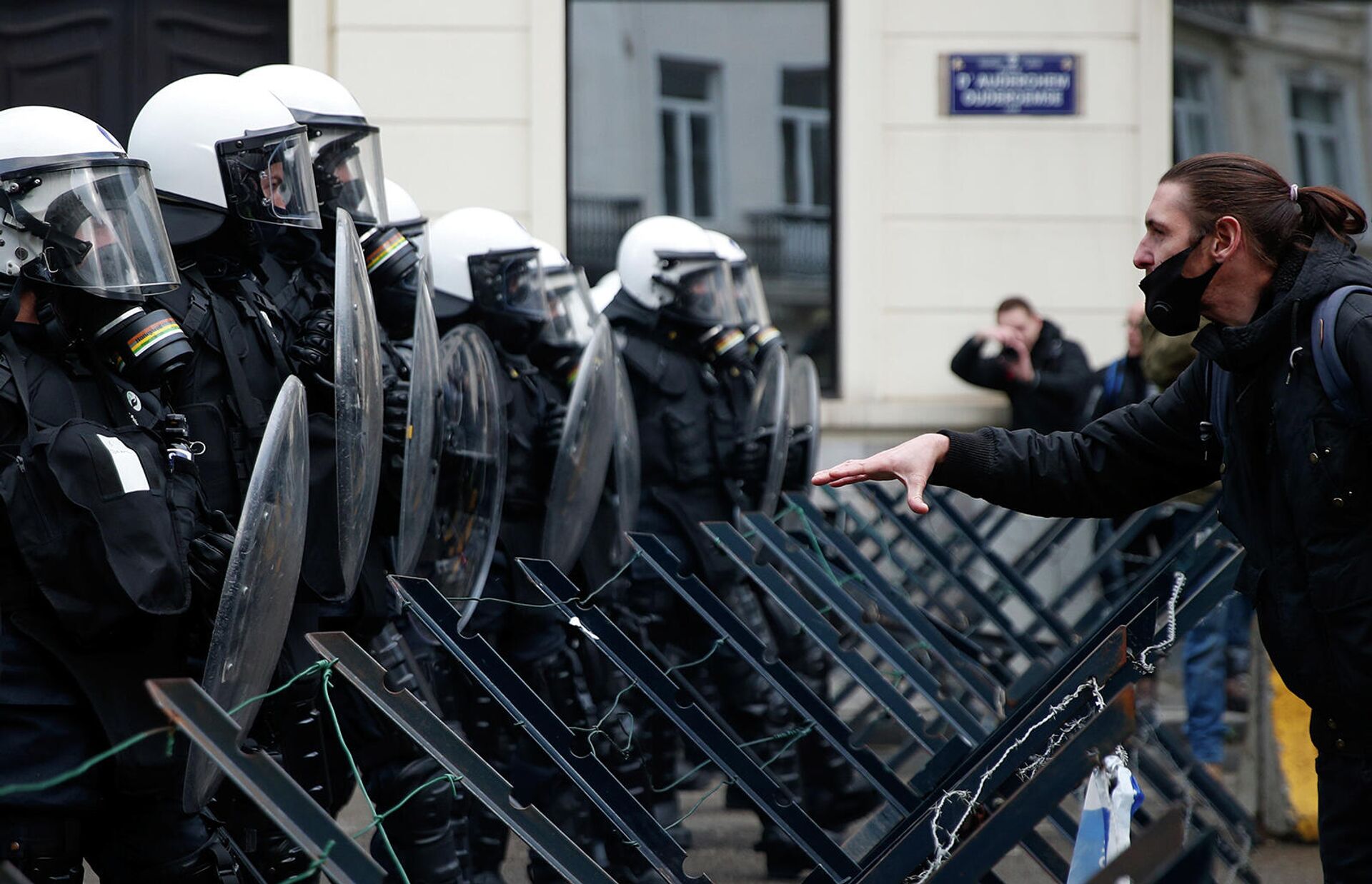 Демонстрант перед полицейскими во время акции протеста против ограничений бельгийского правительства, введенных для сдерживания распространения коронавирусной болезни (5 декабря 2021). Брюссель - Sputnik Армения, 1920, 05.12.2021