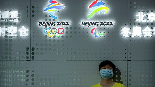 Посетитель возле логотипов зимних Олимпийских и Паралимпийских игр в Пекине в 2022 году на Китайско-Пекинской международной выставке высоких технологий (25 сентября 2021). Пекин - Sputnik Армения