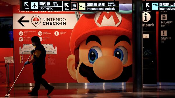 Уборщик моет пол перед баннером игрового персонажа Nintendo's Super Mario в аэропорту Нарита - Sputnik Армения