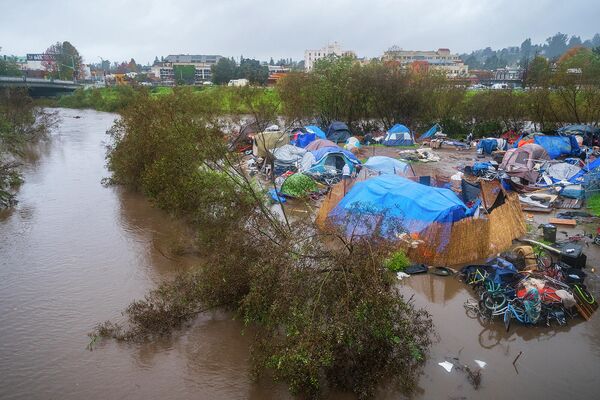 Вышеджая из берегов из-за проливных дождей река Сан-Лоренцо частично затопила лагерь для бездомных в парке Риверуок в Санта-Крус, Калифорния  - Sputnik Армения