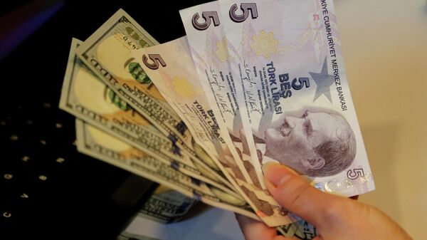 Сотрудник обменного пункта с банкнотами в турецкой лире и долларах США в пункте обмена валюты в Анкаре - Sputnik Армения