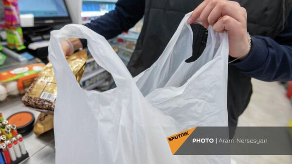 Кассир магазина укладывает покупки в полиэтиленовый пакет - Sputnik Армения