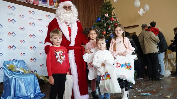Дети с подарками фотографируются с Дедом Морозом на новогоднем представлении - Sputnik Армения