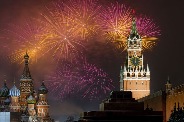 Салют озаряет небо над Кремлем во время новогодних праздников на Красной площади со Спасской башней в Москве 1 января 2022 года - Sputnik Армения