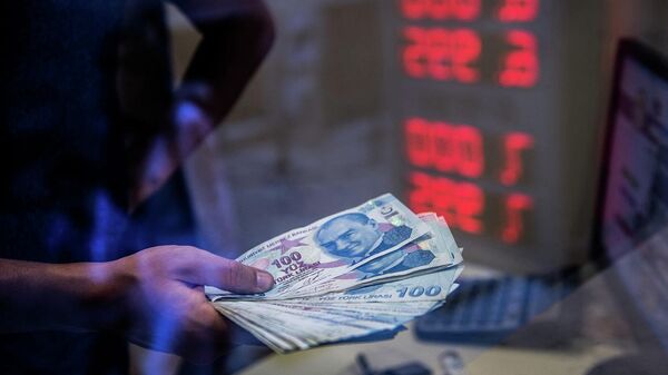 Кассир протягивает банкноты турецкой лиры в обменном пункте в Стамбуле - Sputnik Армения