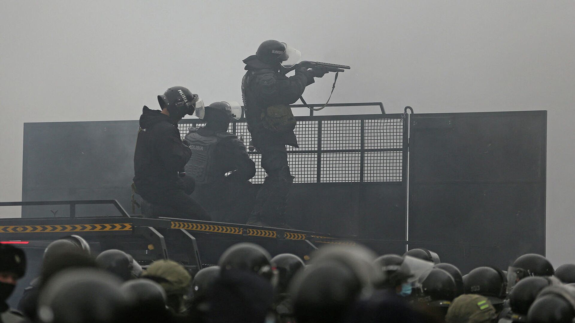 Полицейские целятся из оружия во время акции протеста (5 января 2022). Алматы - Sputnik Армения, 1920, 05.01.2022