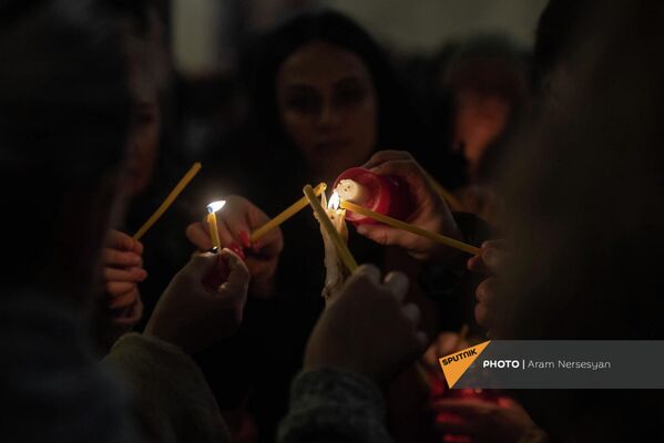 Прихожане зажигают свечи в церкви святой Троицы во время литургии Чрагалуйса (5 января 2022). Еревaн - Sputnik Армения