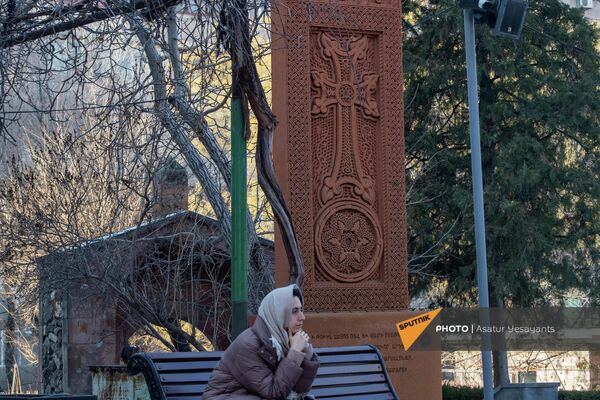 Женщина рядом с хачкаром во дворе церкви Зоравор Сурб Аствацацин. - Sputnik Армения
