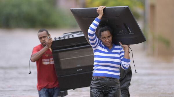 Люди спасают свои вещи из затопленных домов во время сильного наводнения в бразильском штате Minas Gerais - Sputnik Армения