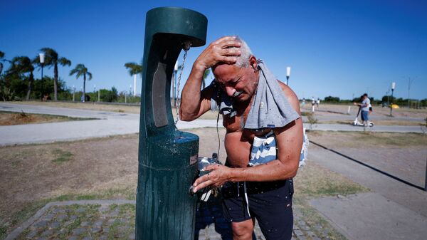 Мужчина освежаетсяина берегу реки Рио-де-ла-Плата во время жары в Буэнос-Айресе - Sputnik Армения