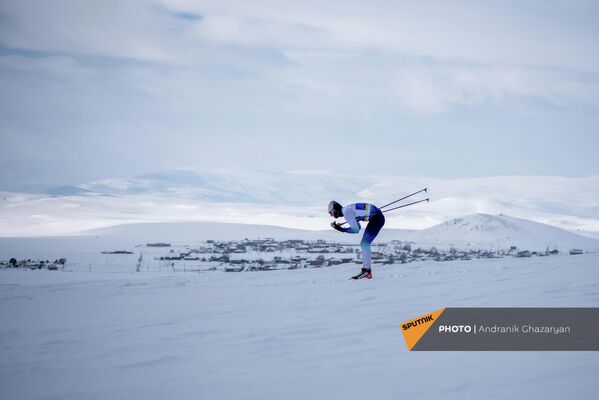 Участник чемпионата Армении по лыжным гонкам спускается с горки - Sputnik Армения