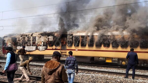 Толпа подожгла вагон поезда из-за предполагаемых недостатков в наборе на работу в железную дорогу (26 января 2022). Индия - Sputnik Армения