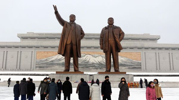 Люди пришли к статуям Ким Ир Сена и Ким Чен Ира во время празднования Нового года по лунному календарю в КНДР - Sputnik Армения