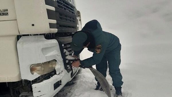 Сотрудник МЧС Армении помогает водителю застрявшей фуры - Sputnik Армения
