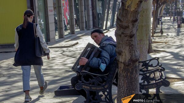 Девушка проходит мимо уличного музыканта, играющего на аккордеоне на проспекте Маштоца - Sputnik Армения