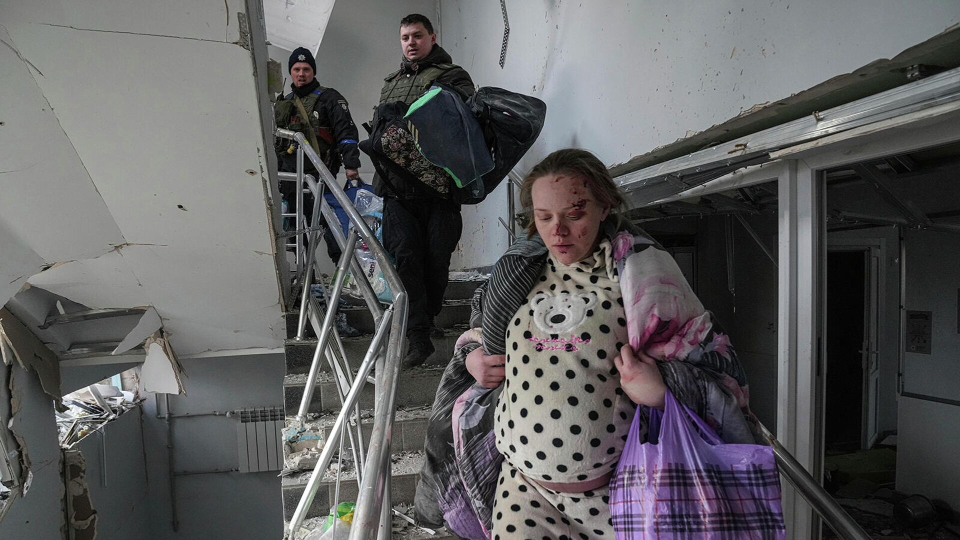 Раненая беременная женщина спускается по лестнице в родильном доме, пострадавшем от обстрела (9 марта 2022). Мариуполь - Sputnik Армения, 1920, 24.03.2022