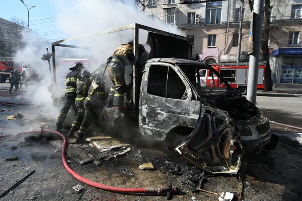 Сотрудники пожарной охраны у разрушенной машины в результате взрыва в центре Донецка.  - Sputnik Армения