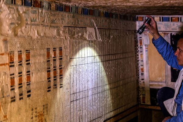 Археолог подсвечивает стену, покрытую иероглифическими гравюрами внутри гробницы Бети - Sputnik Армения