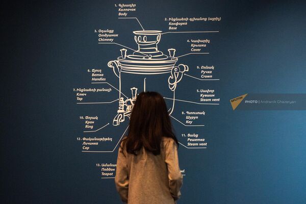 Молодая посетительница изучает графику строения самовара, декорирующую стену на выставке самоваров в Музее Русского искусства - Sputnik Армения