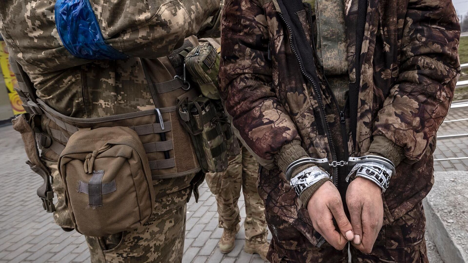 Украинский военнослужащий стоит рядом с закованным в наручники российским солдатом (31 марта 2022). Харьков - Sputnik Армения, 1920, 04.04.2022