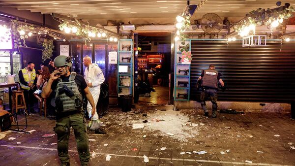 Израильские службы безопасности и спасатели работают у входа в ресторан после инцидента со стрельбой (8 апреля 2022). Тель-Авив - Sputnik Армения