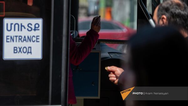 Мужчина протягивает монету в 200 драм для размена водителю в одном из новых автобусов ереванского транспортного парка - Sputnik Армения