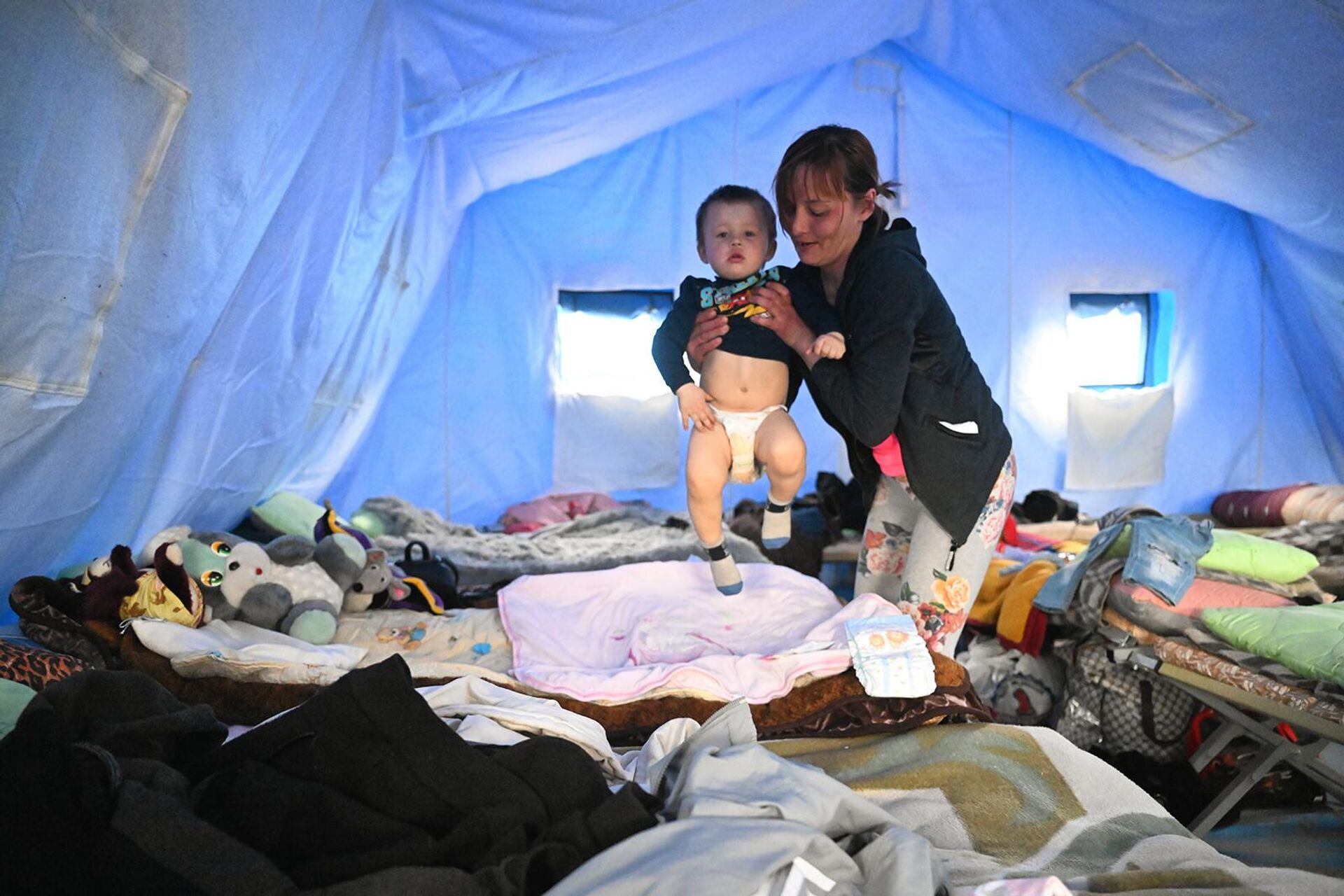Женщина с ребенком в палатке на территории пункта временного размещения эвакуированных из Мариуполя в селе Безыменное - Sputnik Արմենիա, 1920, 19.04.2022